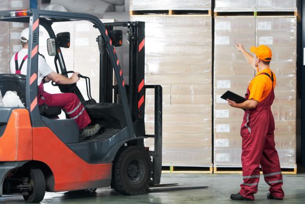 workers using a used forklift in the warehouse.